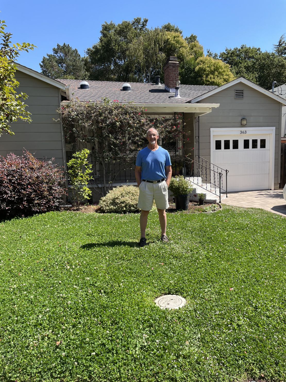 Christian Vescia on his front lawn -- where the grass has been replaced with a low-water ground cover. 