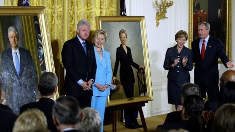 Former US President Bill Clinton (L) and Senator Hillary Clinton (2nd-L) stand by their offical White House portraits during the unveiling event hosted by President George W. Bush (R) and First Lady Laura Bush (2nd-R) 14 June, 2004 in the East Room of the White House  in Washington, DC. The portraits, which will be hung in the Grand Foyer, are the work of self-taught artist Simmie Knox, the first African-American to paint an official presidential portrait.   AFP PHOTO / TIM SLOAN (Photo by Tim SLOAN / AFP) (Photo by TIM SLOAN/AFP via Getty Images)