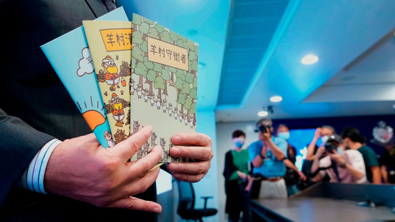 Li Kwai-wah, senior superintendent of Police National Security Department, holds three children's books used as evidence during the sedition law case, during a press conference in July 2021. 
