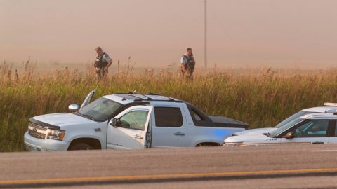 Police and investigators gather at the scene where Myles Sanderson was arrested on Wednesday.