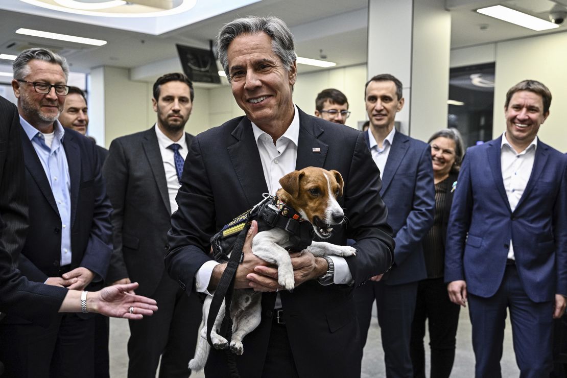US Secretary of State Antony Blinken holds Patron, a landmine sniffer dog, during his visit to a children's hospital in Kyiv.
