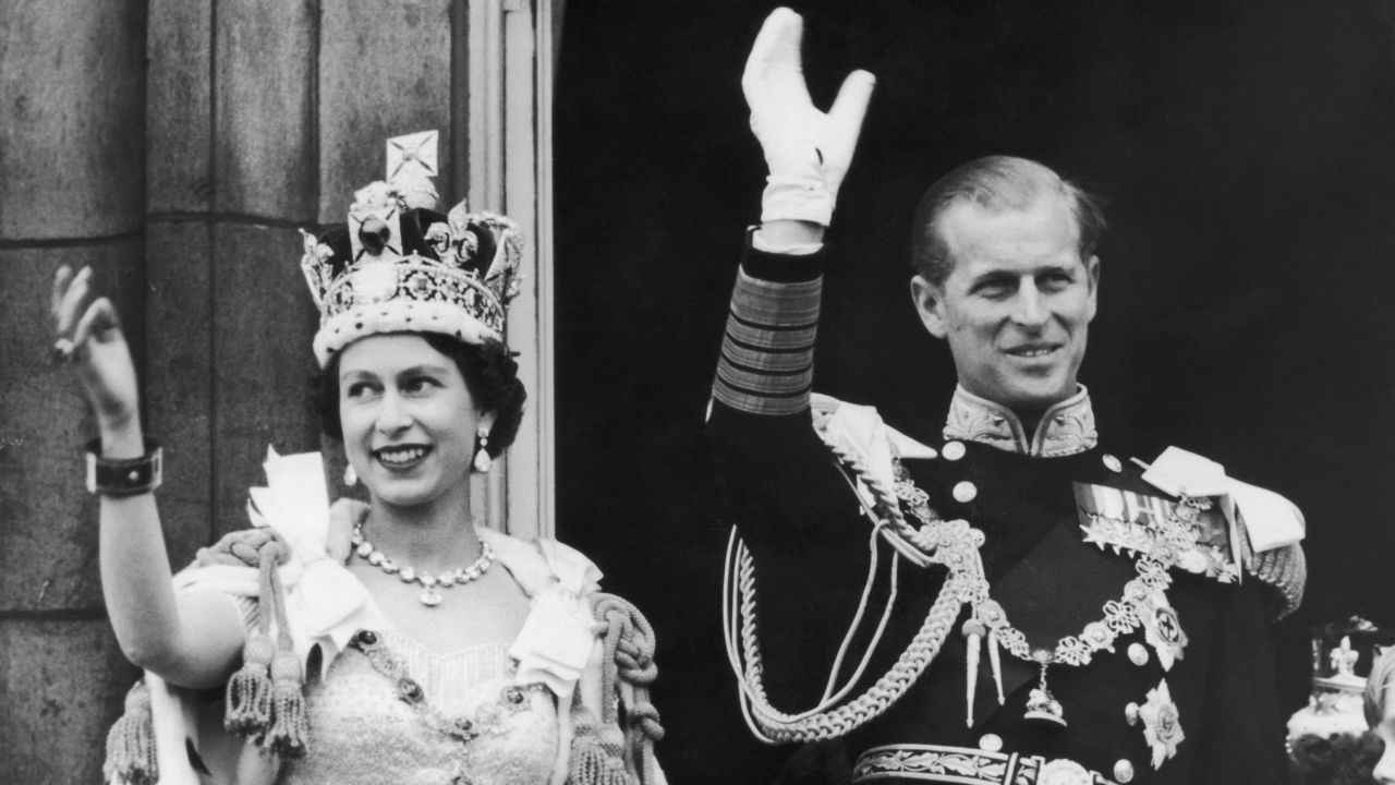 Queen Elizabeth II and the Duke of Edinburgh wave at the crowds from the balcony at Buckingham Palace after her coronation, on June 2, 1953.