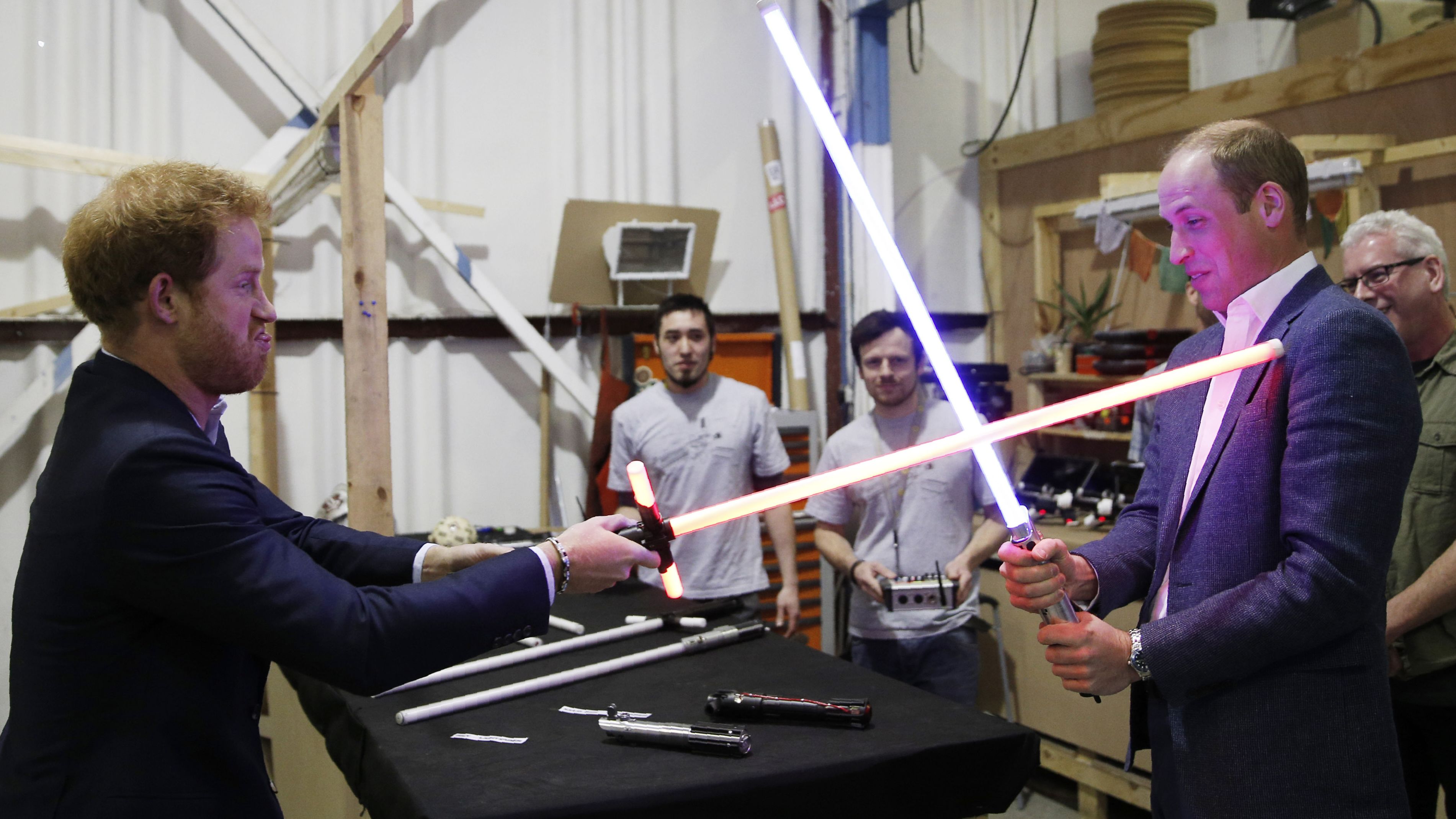 Prince William and Prince Harry try out "Star Wars" lightsabers during a tour of the movie sets in Iver Heath, England, in April 2016.