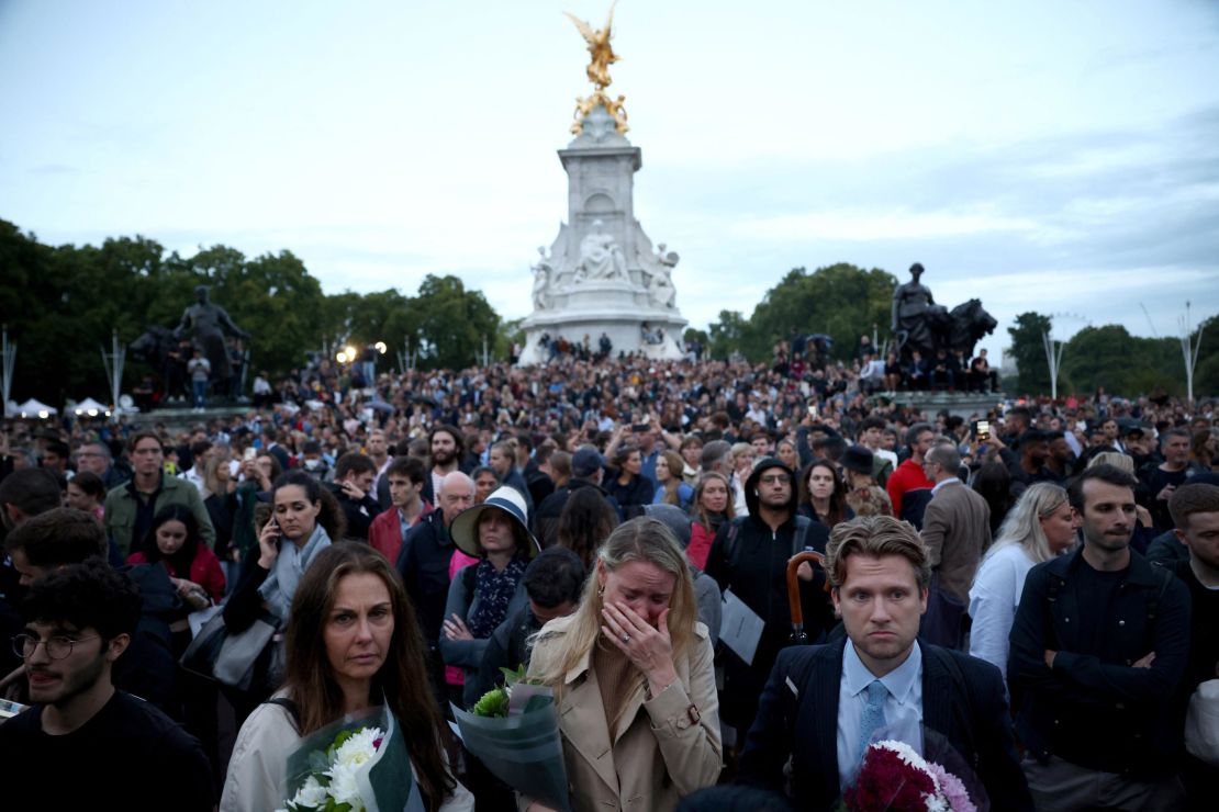 People react outside the Buckingham Palace after the announcement of the death of the Queen.