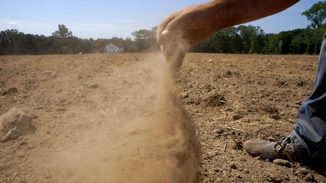 A farmer releases a handful of dry soil in Rhode Island in August. All of Massachusetts, Connecticut and Rhode Island are in drought.