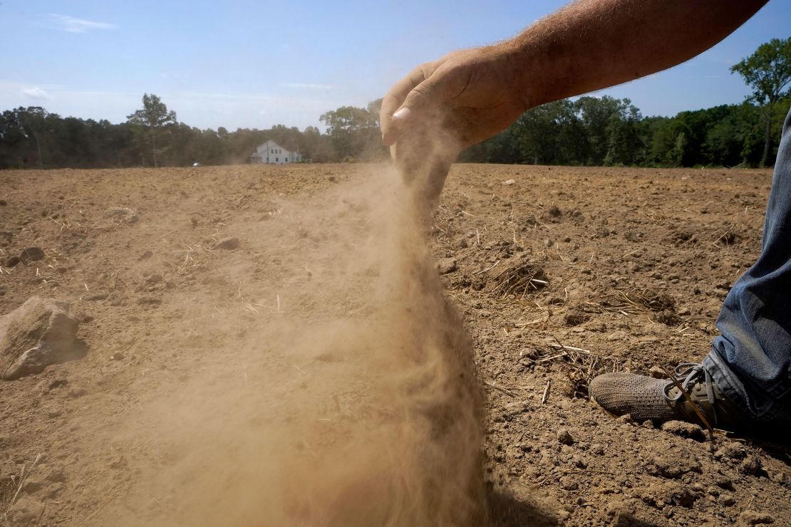 A farmer releases a handful of dry soil in Rhode Island in August. All of Massachusetts, Connecticut and Rhode Island are in drought.