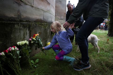 A child places flowers outside the Palace of Holyroodhouse in Edinburgh, Scotland.