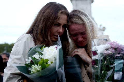 People react outside Buckingham Palace after news of the Queen's death.