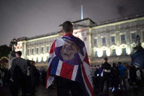 People pay tribute outside Buckingham Palace on Thursday.