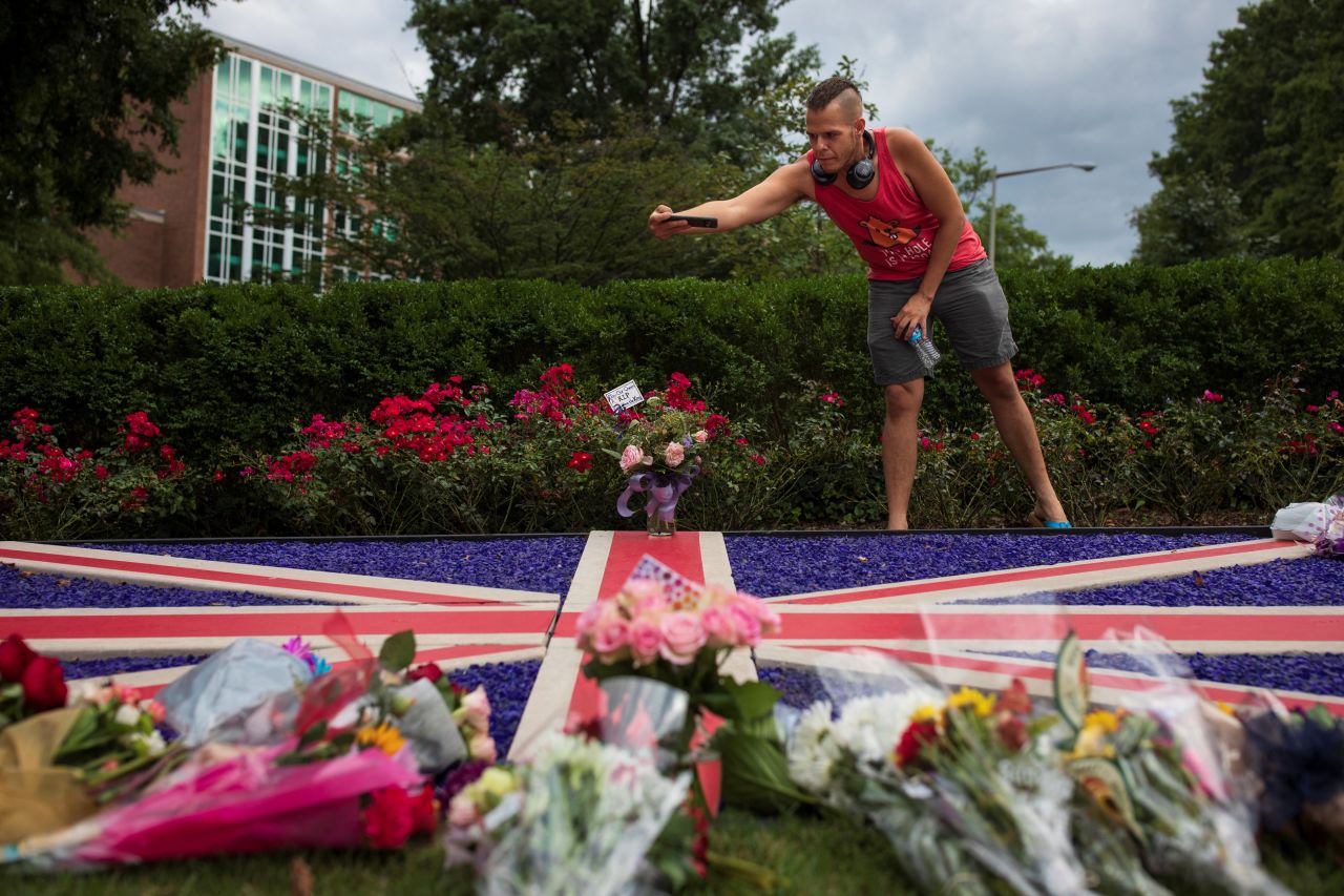 Steven Solice takes pictures of flowers outside the British Embassy in Washington, DC.