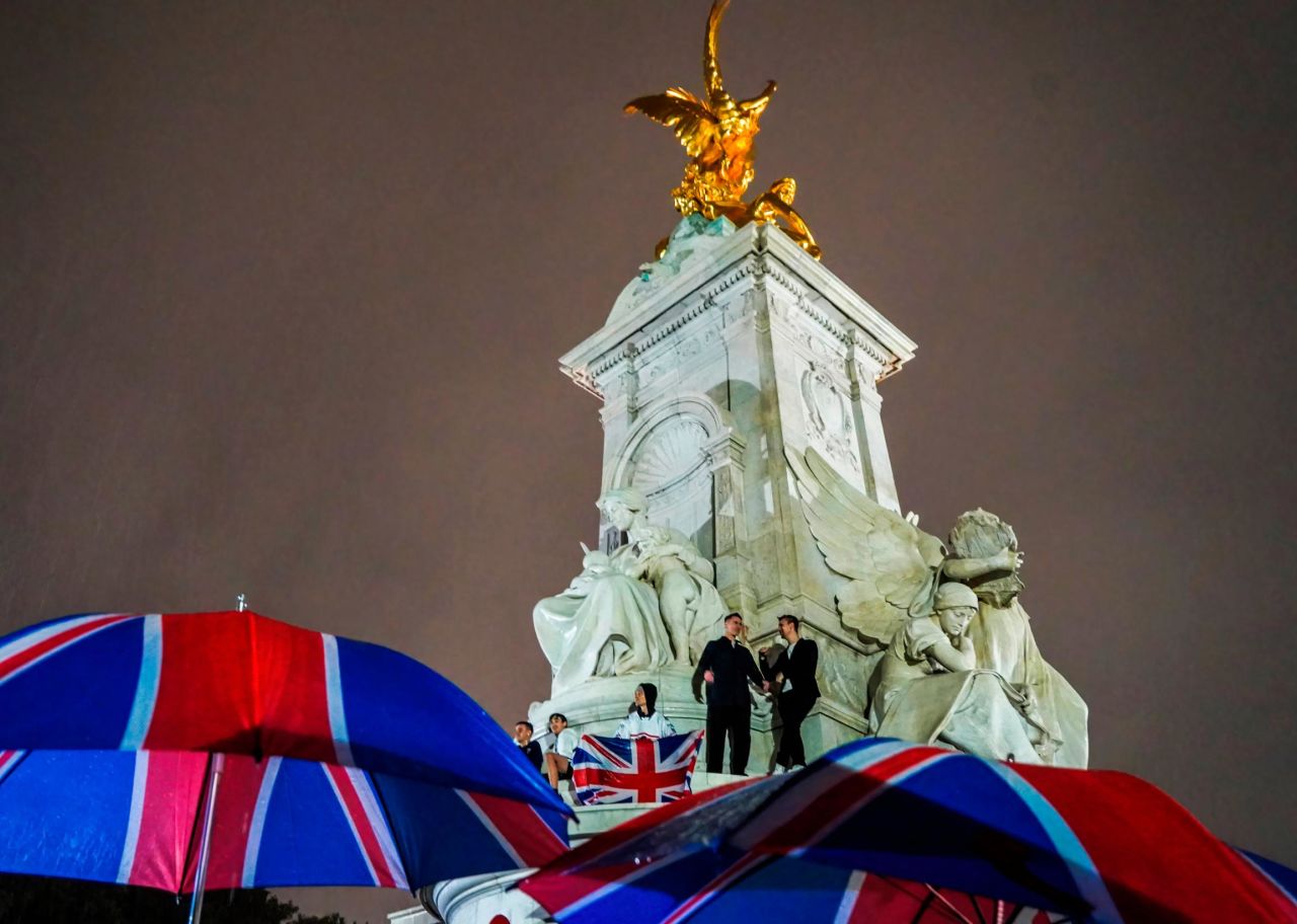 People pay tribute to the Queen outside Buckingham Palace in London.