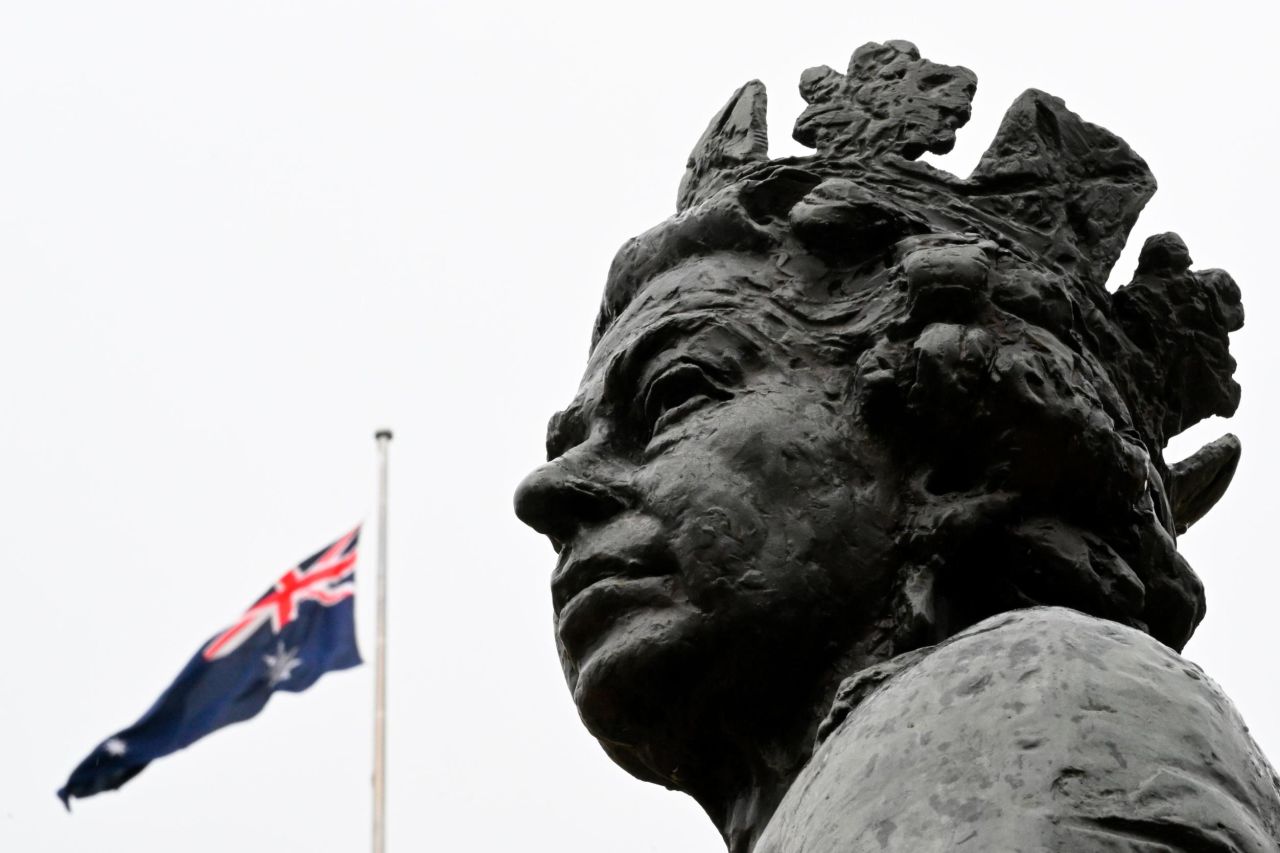 The Australian flag is seen flying at half-staff behind a statue of the Queen outside the Parliament House in Canberra.