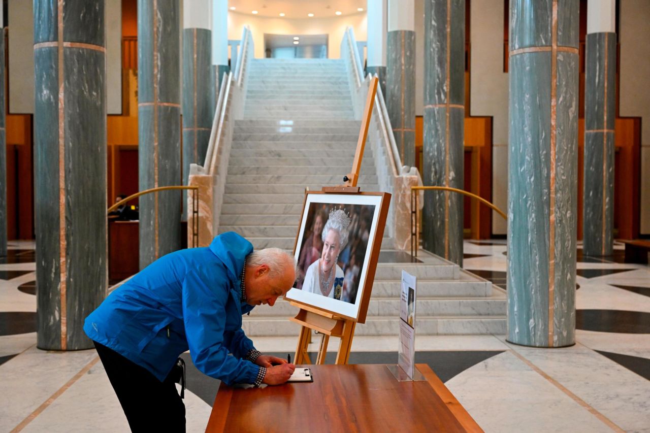 A visitor signs a condolence book for the Queen inside the Parliament House in Canberra, Australia.
