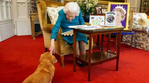 Queen Elizabeth II is joined by one of her dogs, a dorgi called Candy, as she views a display of memorabilia from her Golden and Platinum Jubilees at Windsor Castle on February 4, 2022.