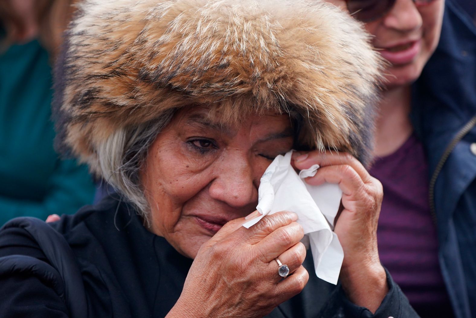 A woman wipes her eyes outside Buckingham Palace.