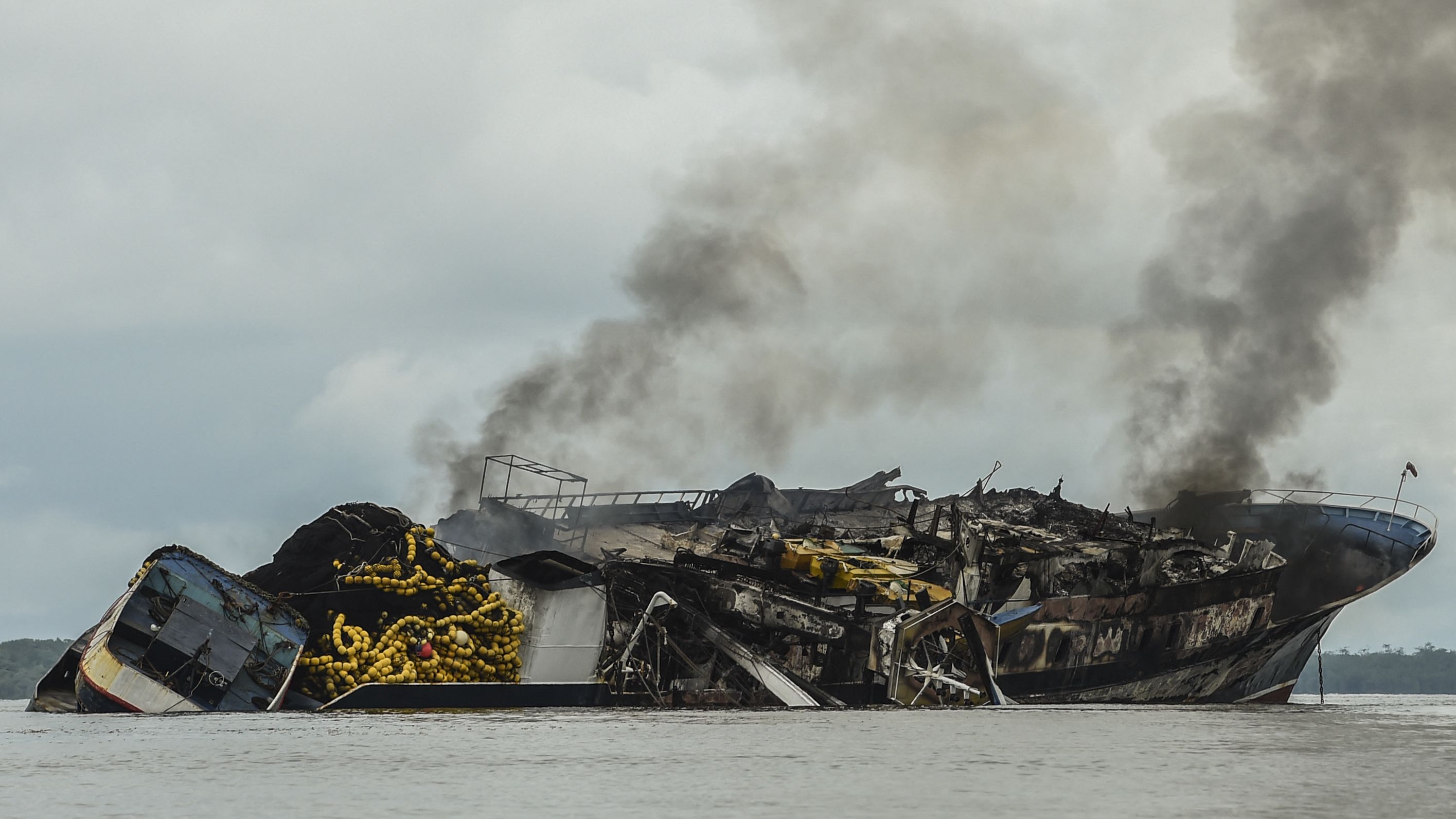 Smoke billows from the Venezuelan ship Taurus 1 as it burns in Colombia's Buenaventura Bay on Tuesday, September 6. Twenty-nine people were rescued after a fire broke out on the boat, the Colombian Navy said.