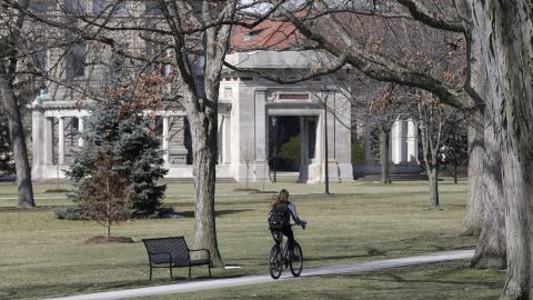 This 2013 file photo shows a student riding a bicycle on the campus of Oberlin College in Oberlin, Ohio. 
