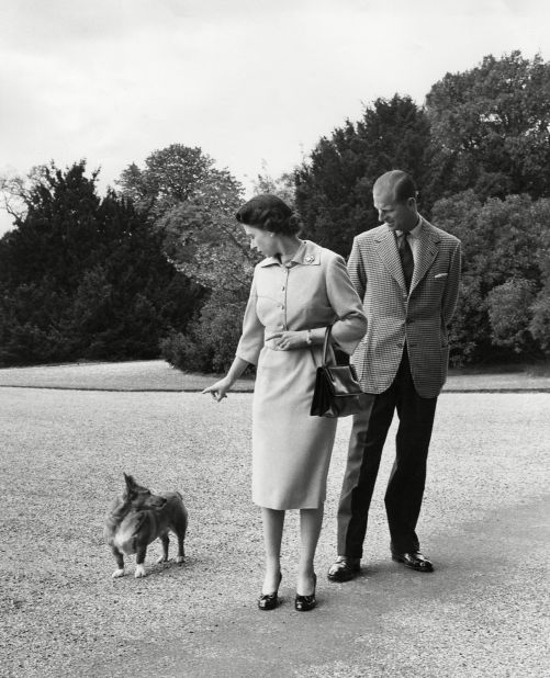 The Queen and Prince Philip watch her corgi Sugar outside Windsor Castle in 1959. 