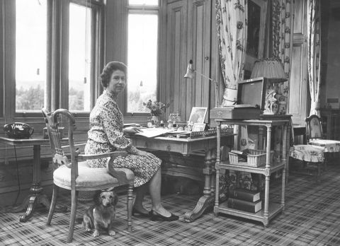 The Queen sits in her study with a corgi at her side at Balmoral Castle in 1972.
