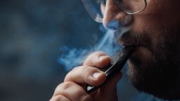 Man smokes with an electronic cigarette, vaping concept.