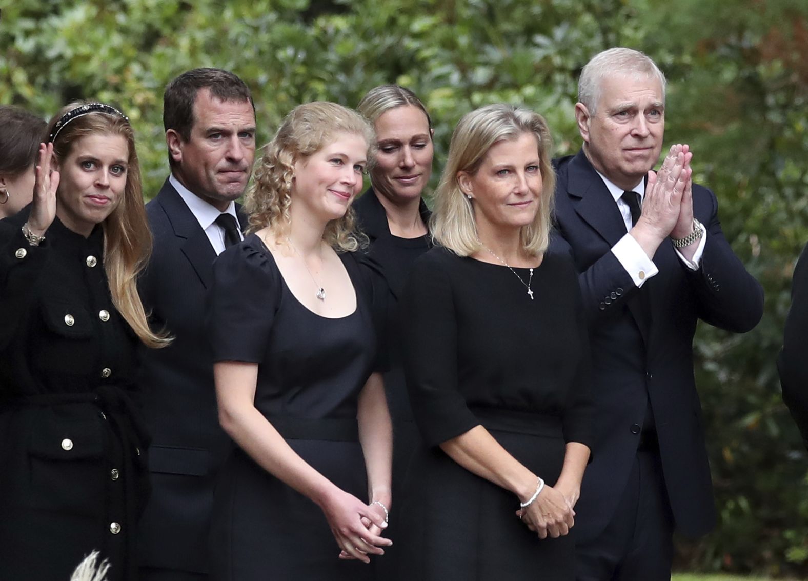 Prince Andrew, right, gestures to the public as members of the royal family look at floral tributes outside the gates of Balmoral Castle on September 10. The royal family attended a private church service at nearby Crathie Kirk.