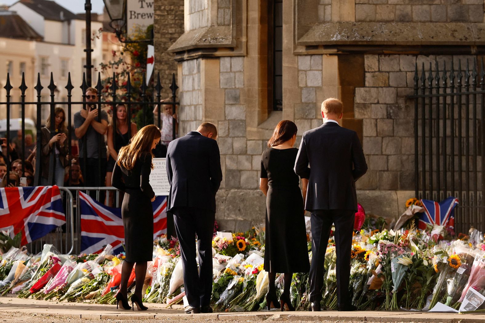 From left, Catherine, Prince William, Prince Harry and Meghan look at floral tributes outside Windsor Castle on September 10.