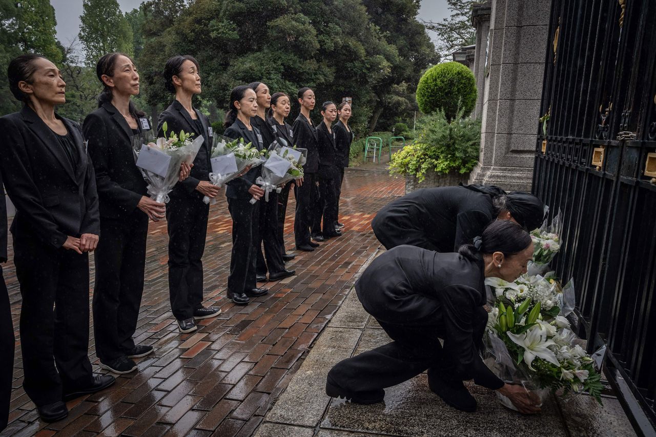 Members of a ballet company lay flowers outside the British Embassy in Tokyo on Friday.