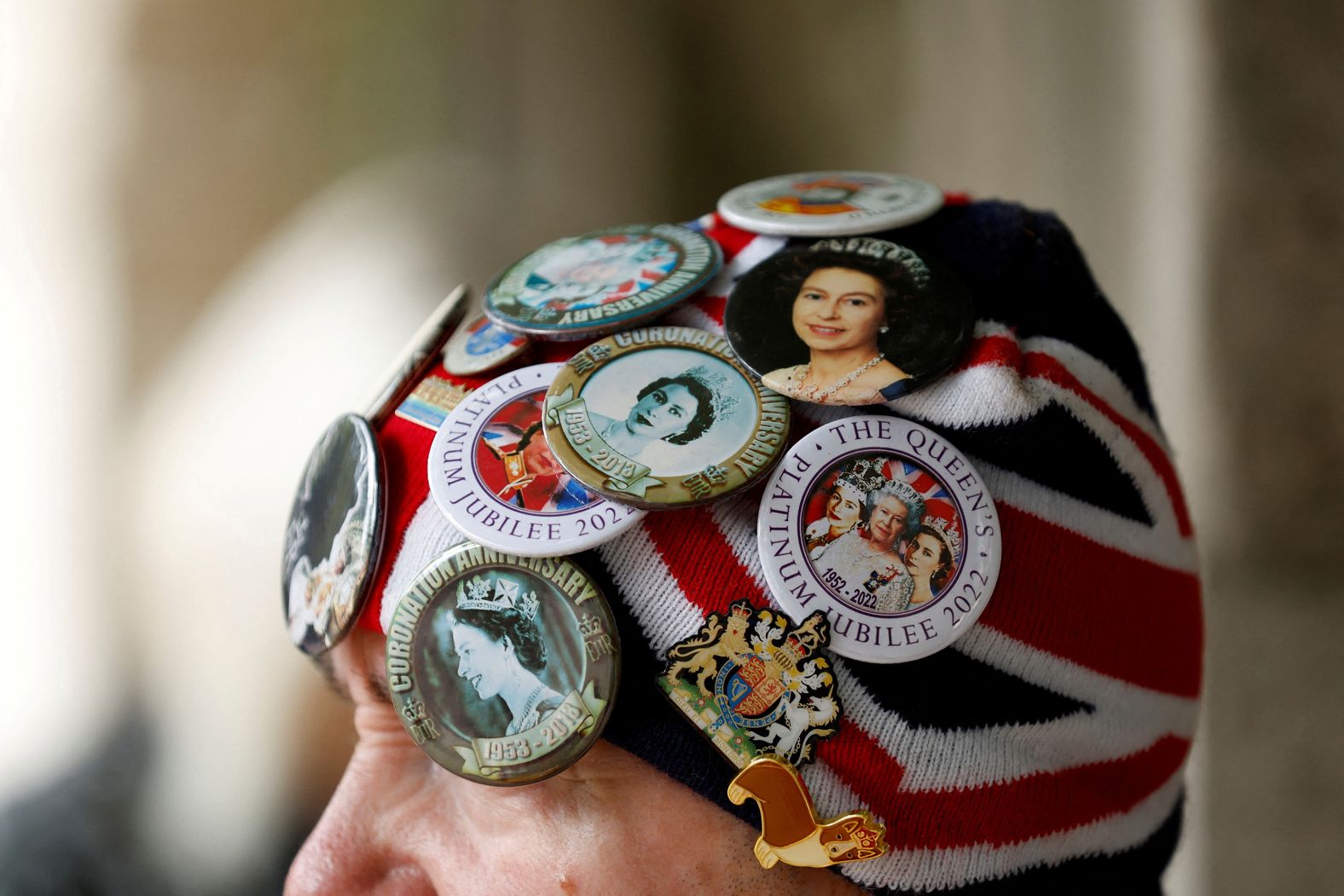 A woman in London sports buttons with pictures of the Queen.