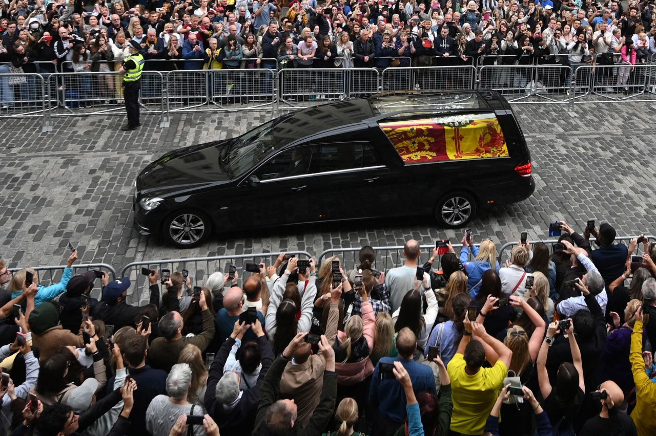 People take photos as a hearse carries the Queen's coffin through Edinburgh on September 11.