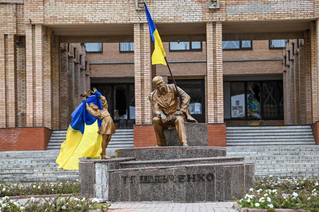 Ukrainian flags are placed on statues in a square in Balakliya on Saturday.