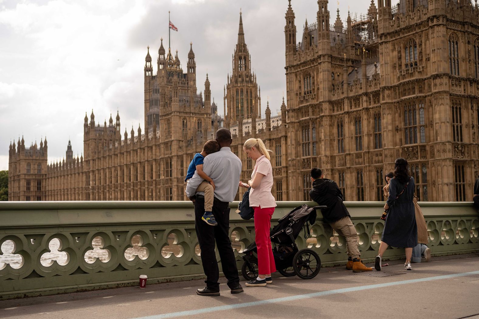 People look at the Palace of Westminster as a flag flies at half-staff on September 11.