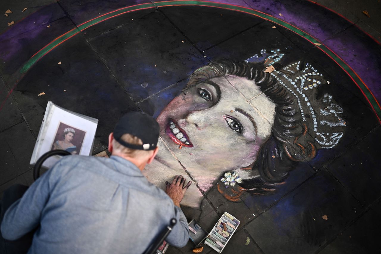 A chalk artist draws a portrait of the Queen at Trafalgar Square in London.