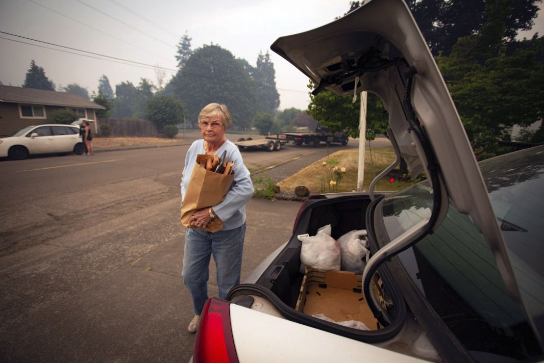 Oakridge, Oregon, resident Patty Beard loads photographs into her car while preparing to evacuate Friday.