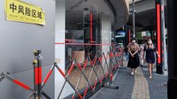 People walk by a closed store at a neighborhood designated as a medium-risk area on July 8, 2022 in Shanghai, China. 