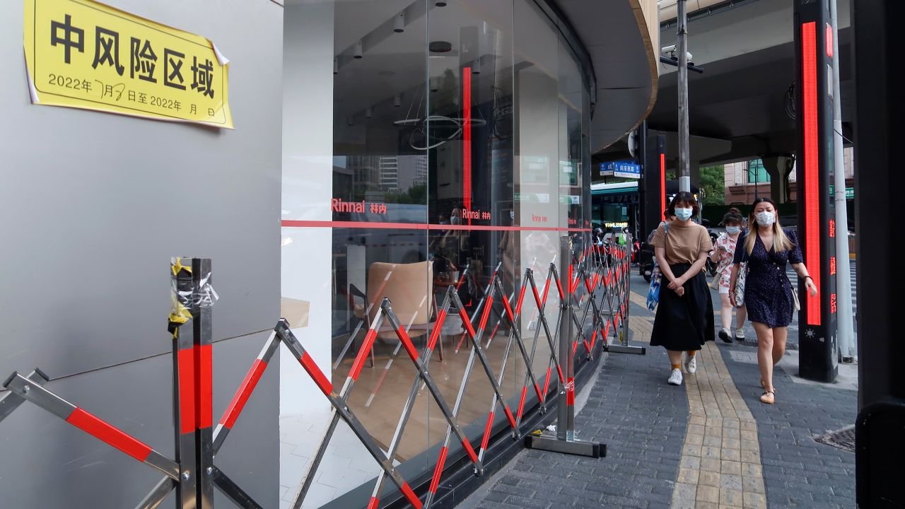 People walk by a closed store at a neighborhood designated as a medium-risk area on July 8, 2022 in Shanghai, China. 