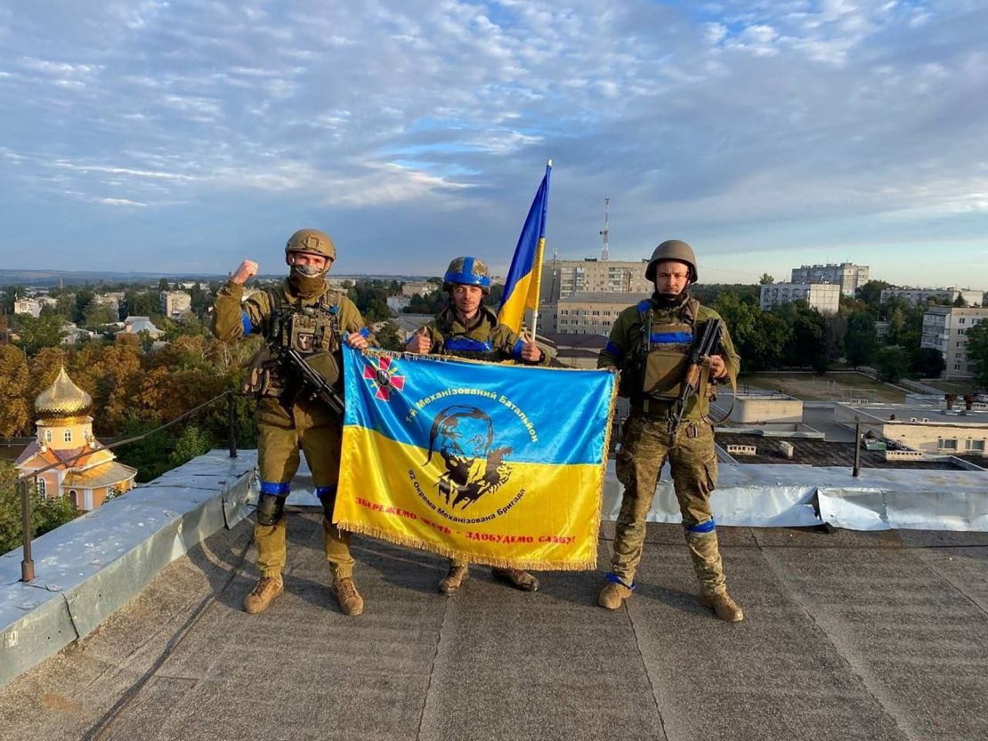 Ukrainian soldiers hold a flag at a rooftop in Kupiansk, Ukraine in this picture obtained from social media released on September 10, 2022. 