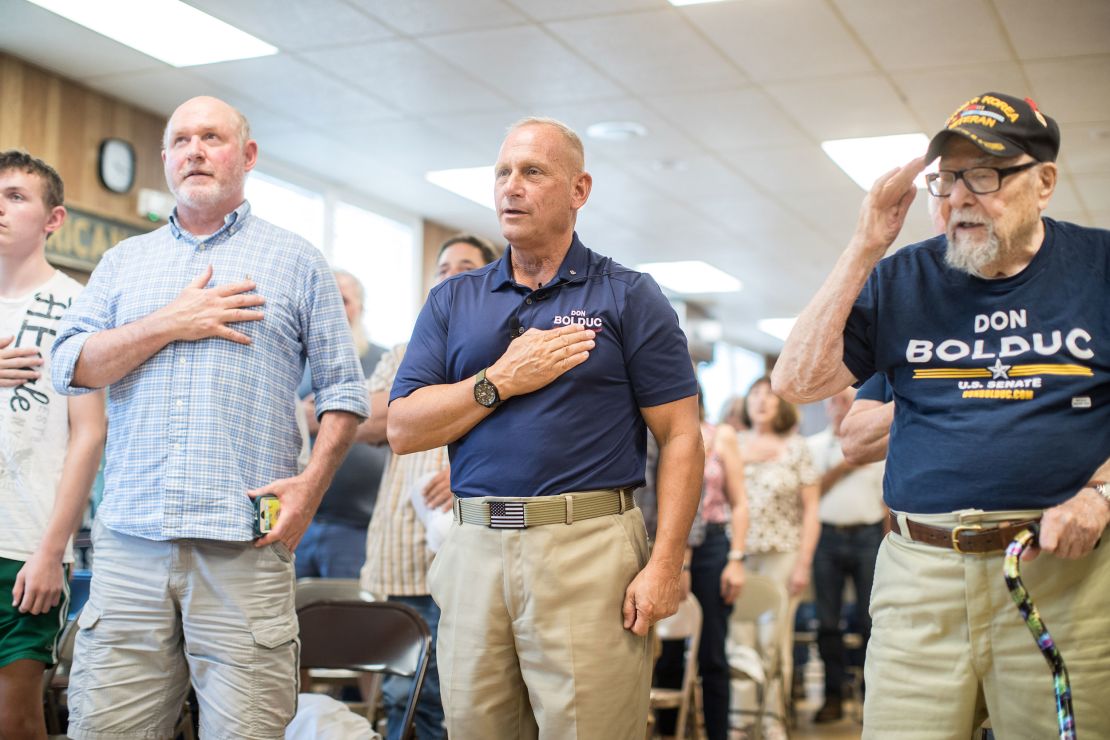 Republican Senate candidate Don Bolduc, center, with supporters at a town hall event during the Pledge of Allegiance on September 10, 2022 in Laconia, New Hampshire.