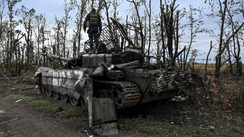 A Ukranian soldier on Sunday standis atop an abandoned Russian tank near a village on the outskirts of Izyum, Ukraine.