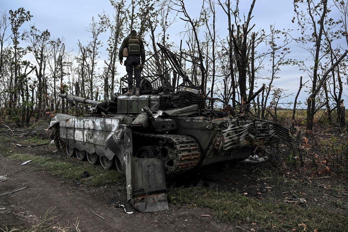 A Ukranian soldier on Sunday standis atop an abandoned Russian tank near a village on the outskirts of Izyum, Ukraine.
