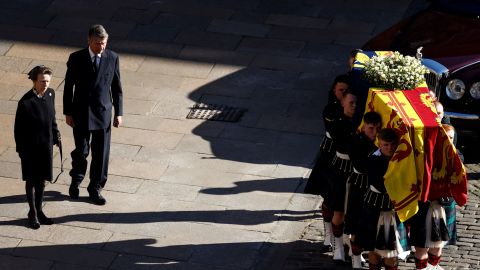 Princess Anne and her husband Vice Admiral Timothy Laurence watch pallbearers carrying the Queen's coffin in Edinburgh.