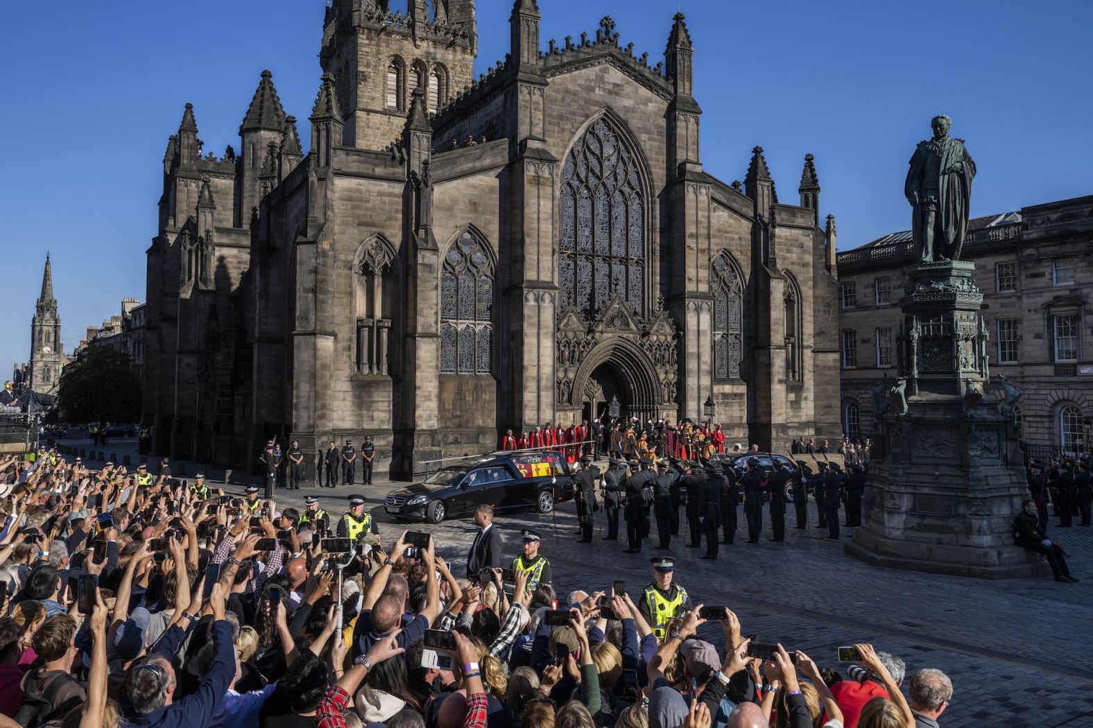 People watch as the Queen's coffin is transported to Edinburgh Airport on Tuesday.