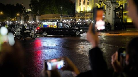 A hearse carrying the Queen's coffin arrives at Buckingham Palace on Tuesday. The coffin was flown in Tuesday from Edinburgh, Scotland.