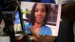 A family member holds an image of Tiffany Fletcher at a press conference about her murder. 