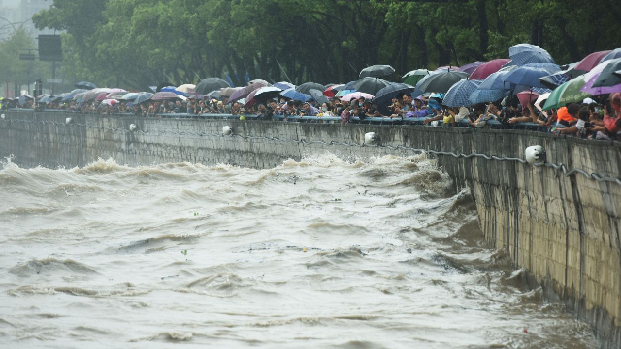 People watch the high tide of the Hangzhou section of the Qiantang River in Zhejiang Province, China, September 13, 2022.  
