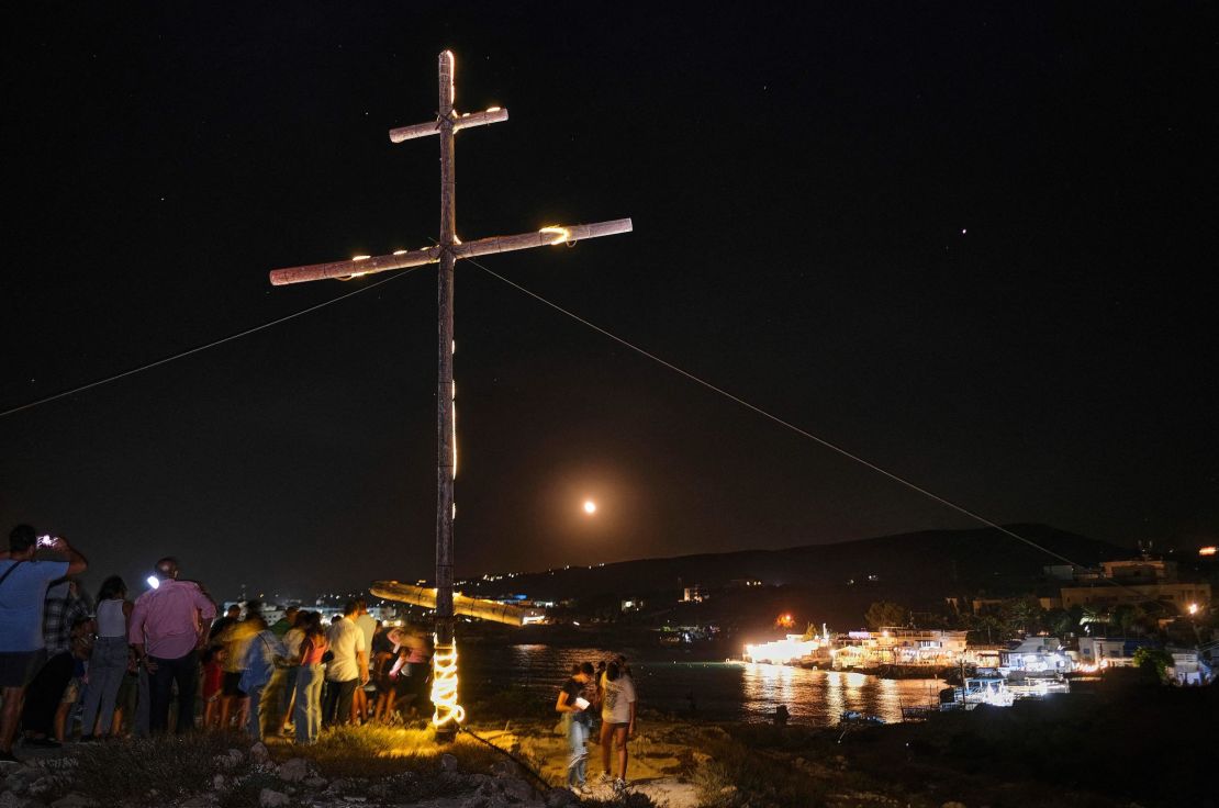 Christian Greek Orthodox worshippers gather on a cliff around a lit wooden crucifix to celebrate the Exaltation of the Holy Cross in the coastal town of Anfeh, some 70 kilometers (43 miles) north of the Lebanese capital, Beirut, on Tuesday.  