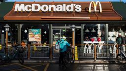 A Deliveroo rider stands beside a bicycle outside a McDonald's restaurant in London, Britain, December 10, 2021. Picture taken December 10, 2021. REUTERS/May James