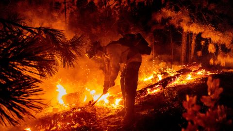 A firefighter manages a backfire, flames lit by firefighters to burn off vegetation, while battling the Mosquito Fire in Placer County Tuesday.