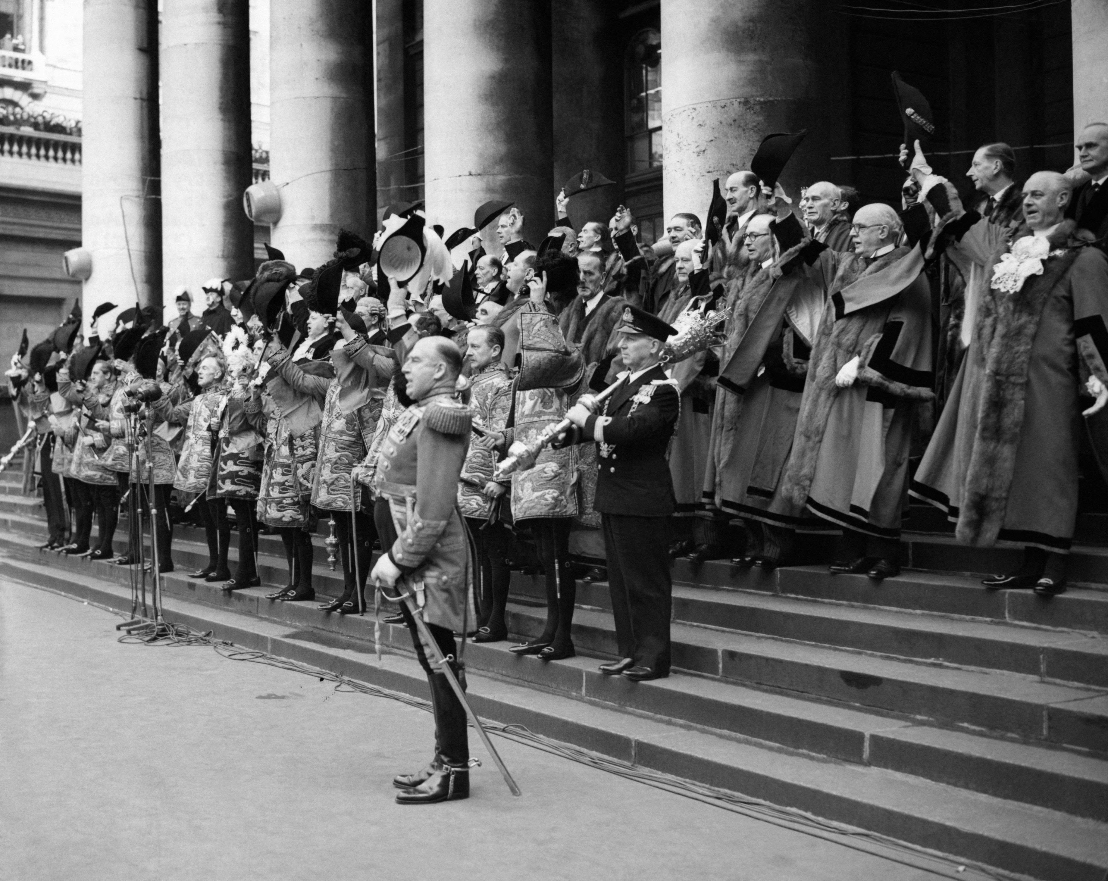 Dignitaries raise their hats and cheer for the Queen after the reading of the proclamation at the Royal Exchange in London.