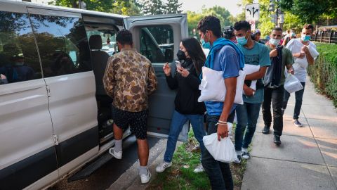 Migrants head into vans near the US Naval Observatory after being dropped off there Thursday. 