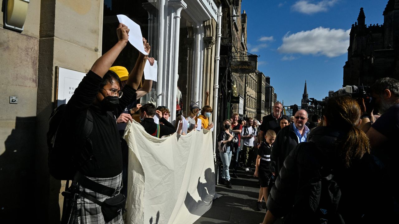 Anti-monarchy protesters hold up blank signs during royal ceremonies in Edinburgh on Tuesday.